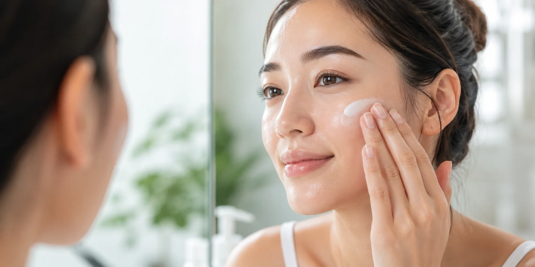 Woman applying day cream on her face in the morning